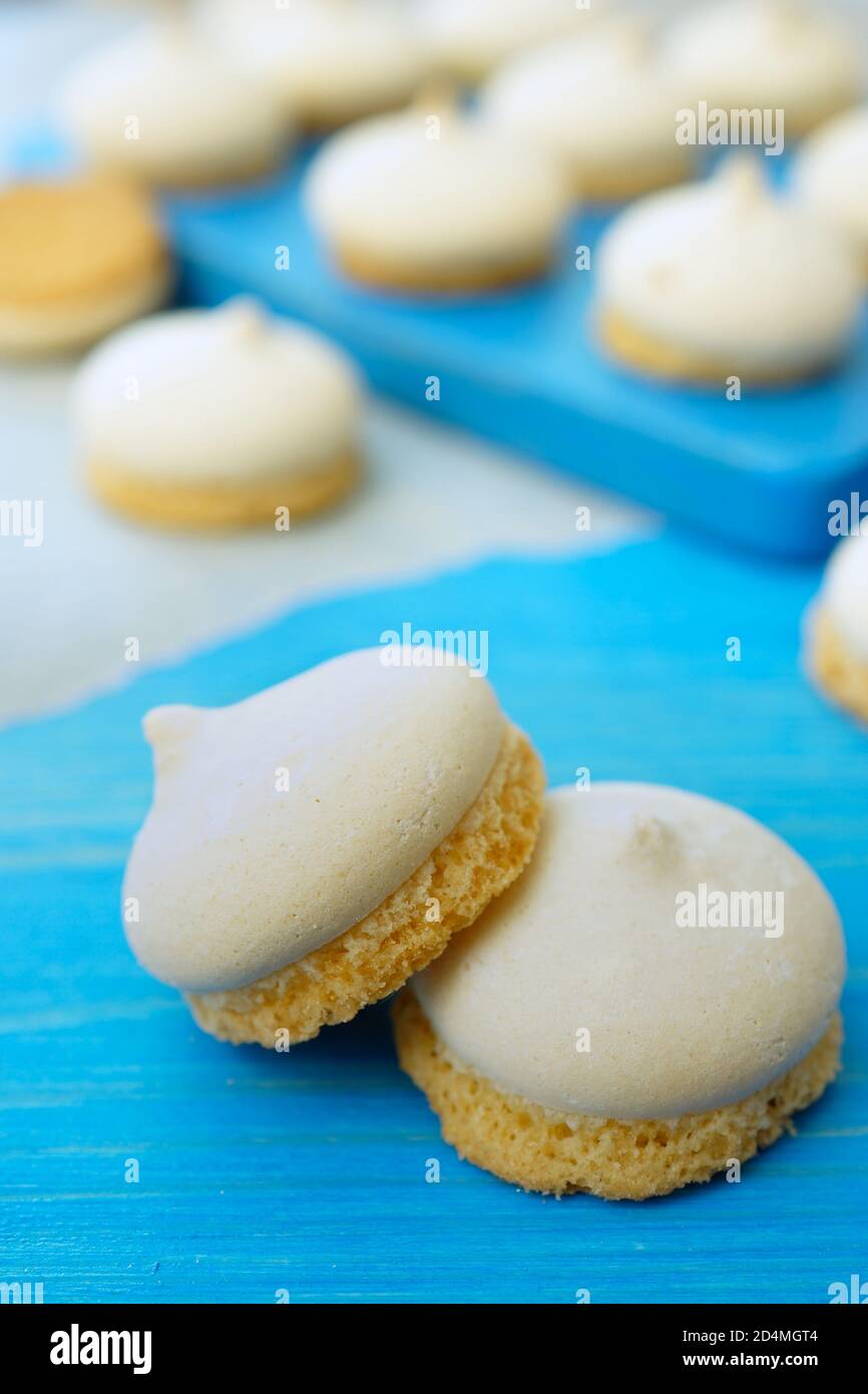 Meringa torta d'aria. Biscotti di meringa appena sfornati su un tavolo blu. Primo piano. Foto Stock