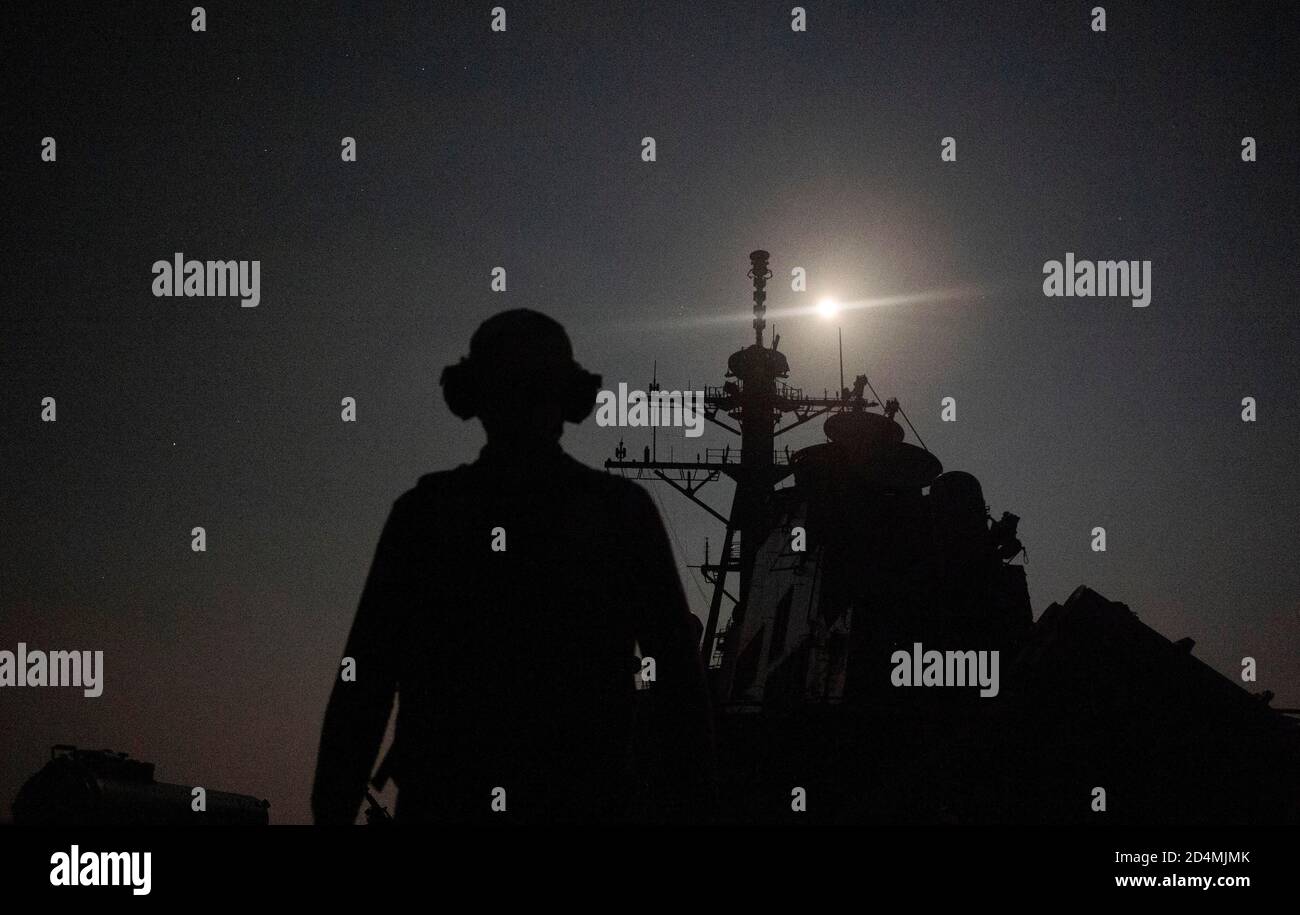 201005-N-XG173-1083 GOLFO ARABICO (OTT 5, 2020) Mate machinista 3a Classe Jonathan Downs, di San Antonio, assegnato al cacciatorpediniere missilistico guidato USS John Paul Jones (DDG 53), si prepara a segnalare un elicottero MH-60S Sea Hawk dagli "Screamin' Indians" dello Squadrone di combattimento marittimo dell'elicottero (HSC) 6 nel Golfo Arabico, 5 ottobre durante le operazioni di volo notturno. John Paul Jones fa parte del Nimitz Carrier Strike Group e viene distribuito nella quinta area operativa della flotta statunitense per garantire la stabilità marittima e la sicurezza nella regione centrale, collegando il Mediterraneo e il Pacifico attraverso l'area occidentale Foto Stock