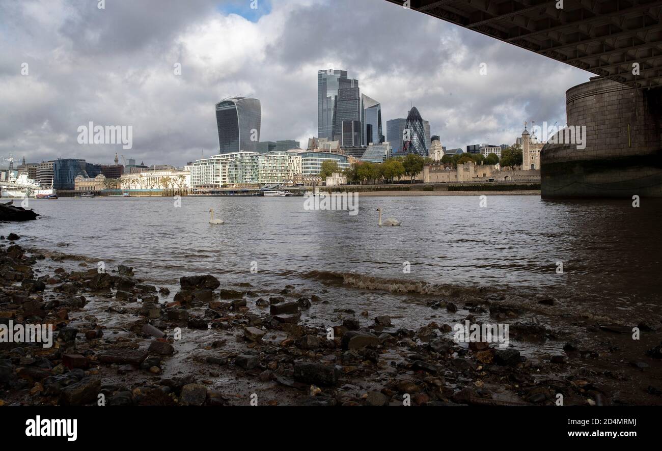 Londra, Gran Bretagna. 6 Ott 2020. I cigni sono visti sul Tamigi sullo sfondo della città di Londra, a Londra, Gran Bretagna, il 6 ottobre 2020. Il prodotto interno lordo (PIL) della Gran Bretagna ha registrato il quarto aumento mensile consecutivo nell'agosto 2020, ma è rimasto ben al di sotto dei livelli pre-pandemici, ha detto l'Ufficio britannico per le statistiche nazionali (ONS) il 9 ottobre. Credit: Han Yan/Xinhua/Alamy Live News Foto Stock