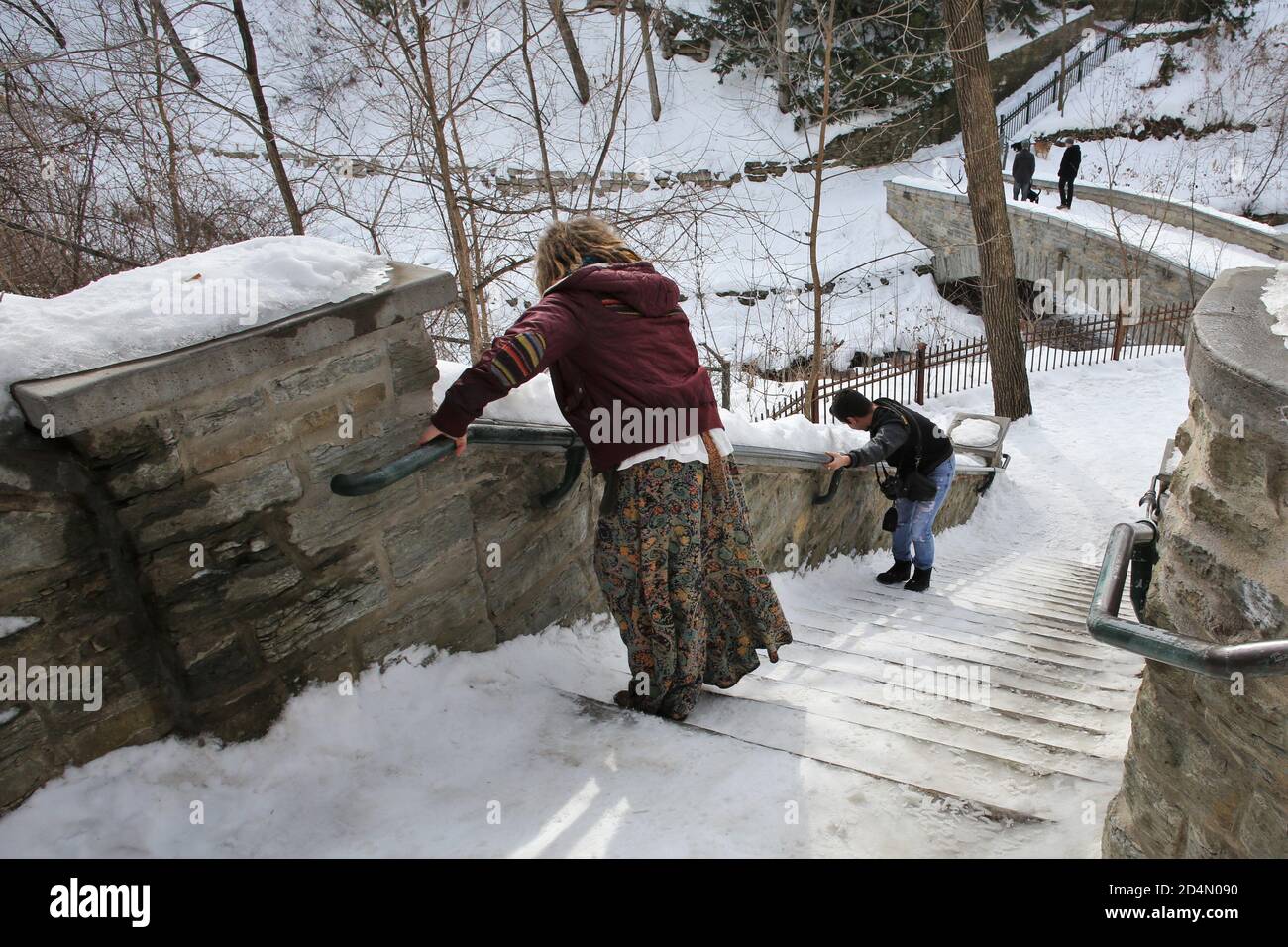 Le persone che si stringono a un corrimano mentre cercano di scendere i gradini ghiacciati nel parco Minnehaha a Minneapolis, Minnesota. Foto Stock