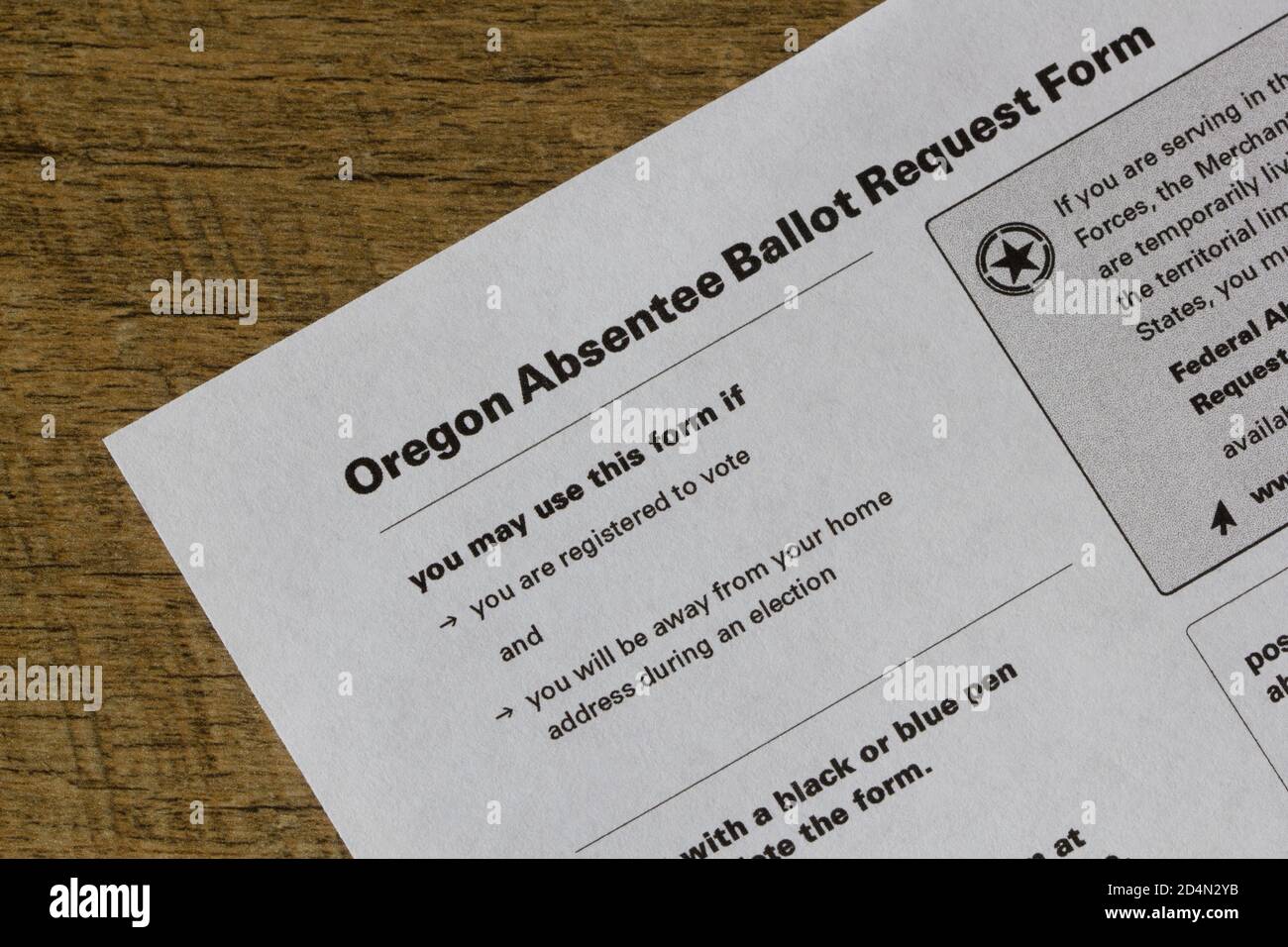 Closeup di un modulo di richiesta di voto degli assenti dello stato dell'Oregon su sfondo di legno. Foto Stock