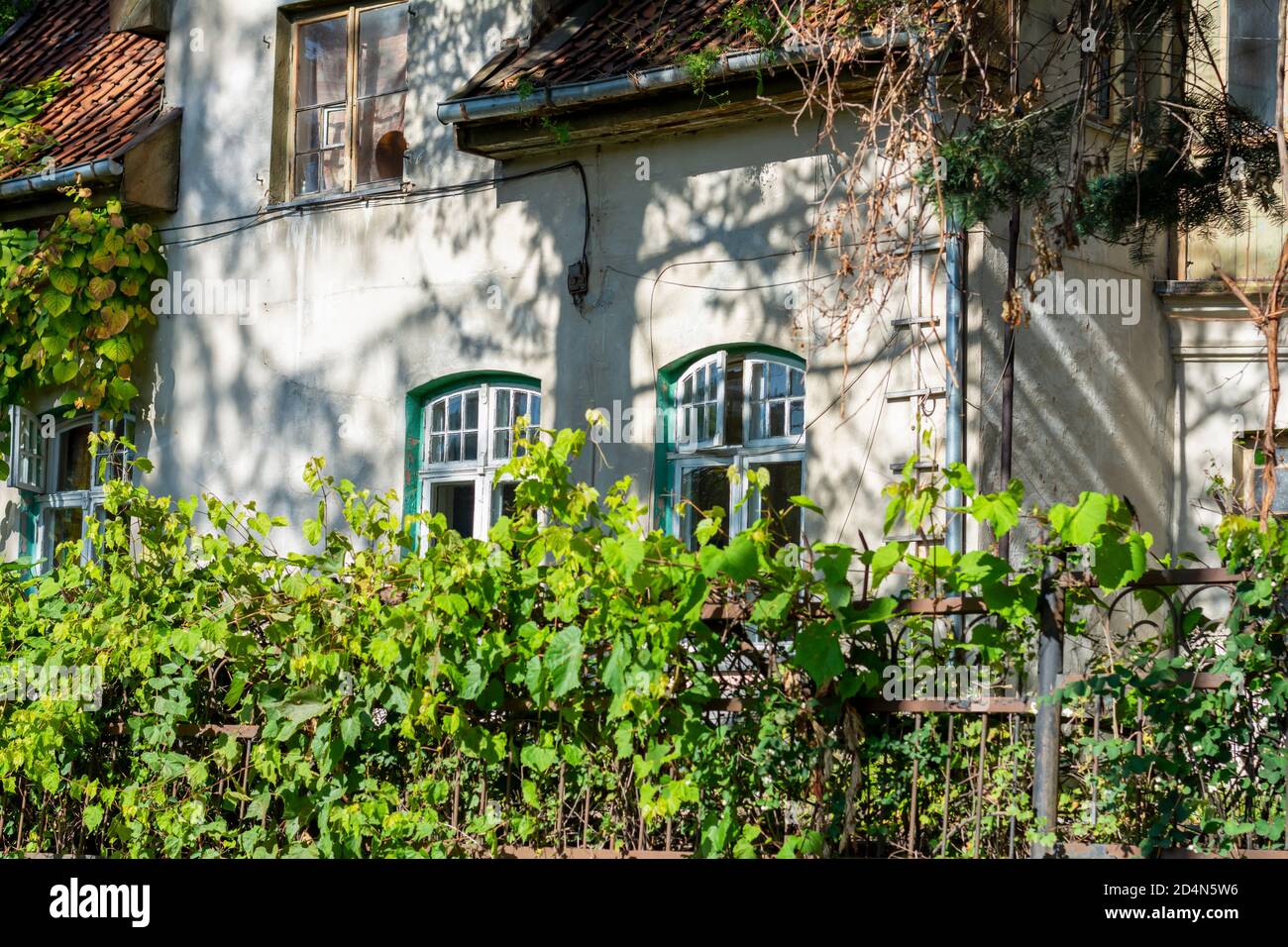 Facciata di una vecchia casa con finestre e piastrelle in legno. casa del 19 ° secolo senza restauro. Foto Stock