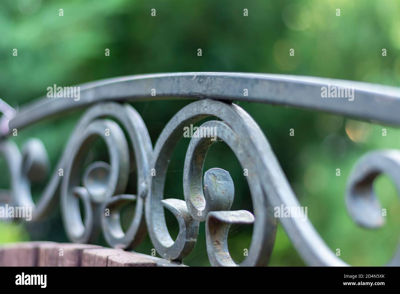 Elemento in ferro battuto di una panca cittadina. Bellissimo modello nel prodotto. Primo piano, messa a fuoco selettiva, profondità di campo poco profonda. Foto Stock