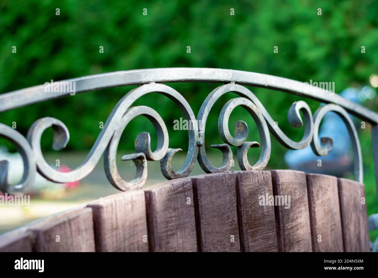 Elemento forgiato di panca nel parco cittadino. Bellissimo modello di ferro. Primo piano, messa a fuoco selettiva, profondità di campo poco profonda. Foto Stock
