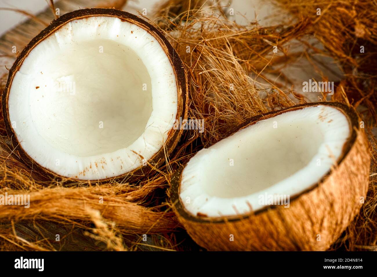 Due metà di cocco su fondo di fibra di cocco Foto Stock