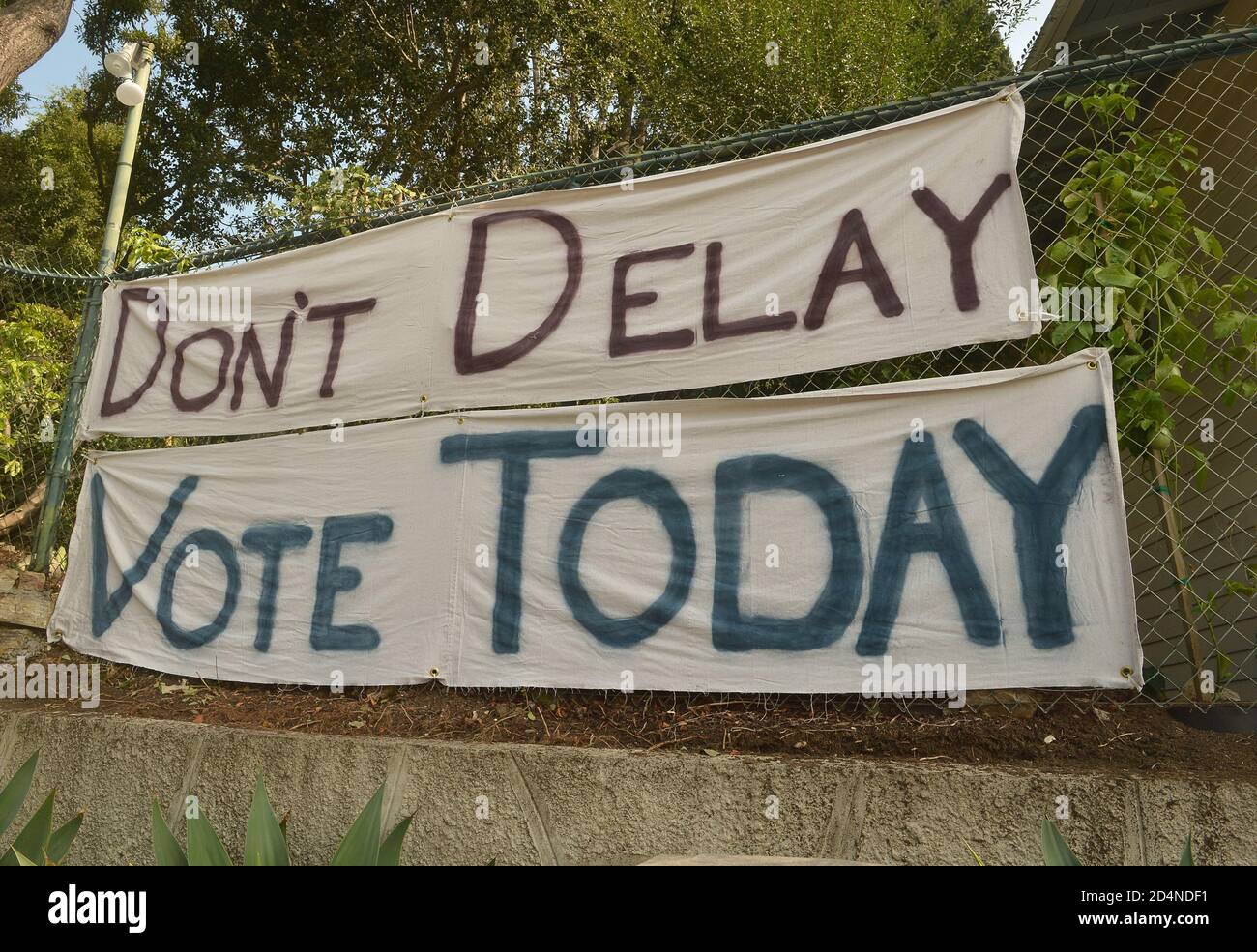 Los Angeles, Stati Uniti. 10 Ott 2020. Un banner su una recinzione spinge gli elettori a 'non ritardare il voto di oggi' per le prossime elezioni generali nella sezione Silver Lake di Los Angeles, venerdì 10 ottobre 2020. Meno di un mese prima del giorno delle elezioni, un numero senza precedenti di americani ha già lanciato i propri voti, indicando una possibile affluenza record per la corsa tra il presidente in carica Trump e il rivale democratico Joe Biden. Foto di Jim Ruymen/UPI Credit: UPI/Alamy Live News Foto Stock