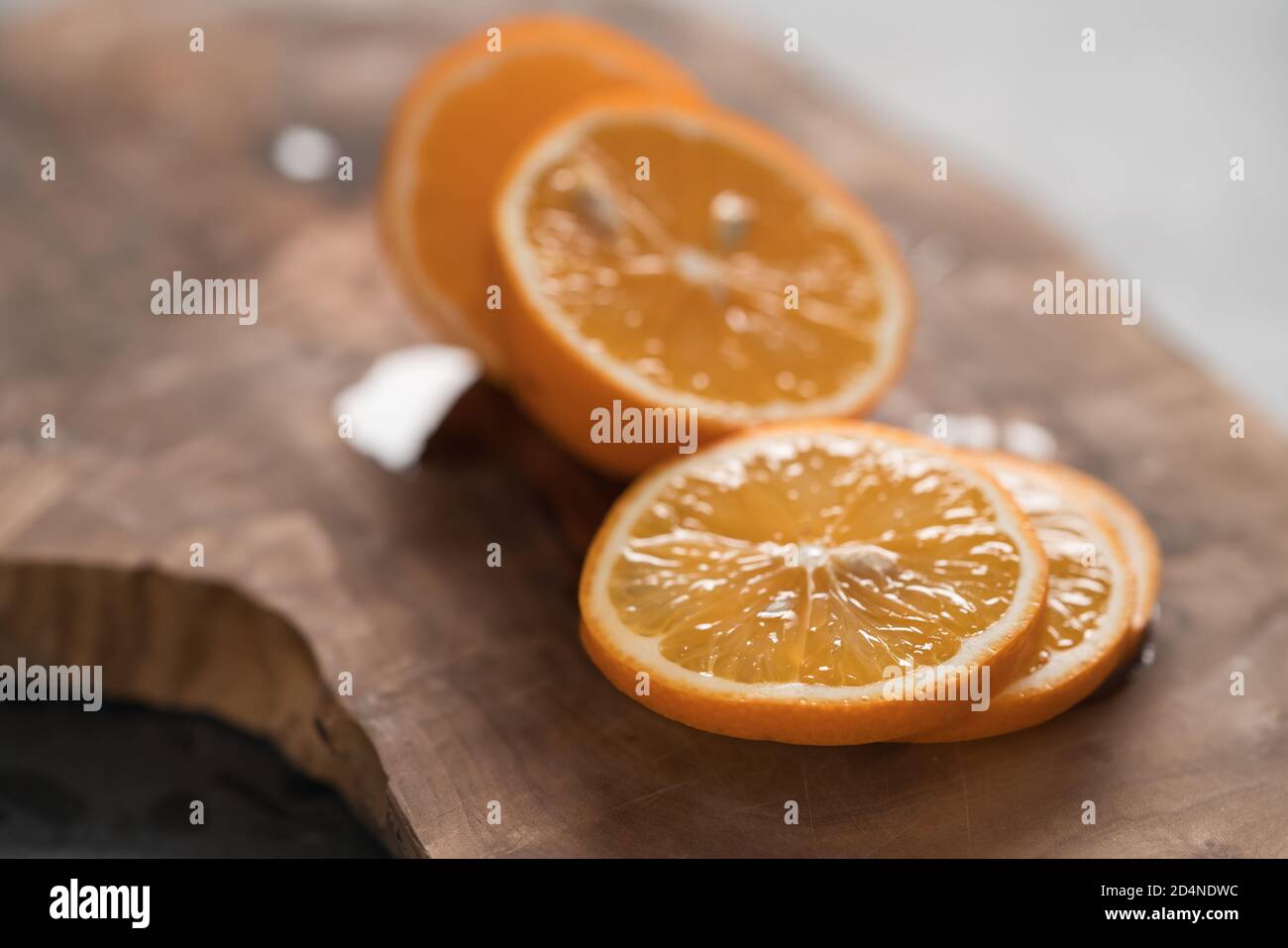 Limone arancione a fette su tavola di ulivo closeup, fuoco basso Foto Stock