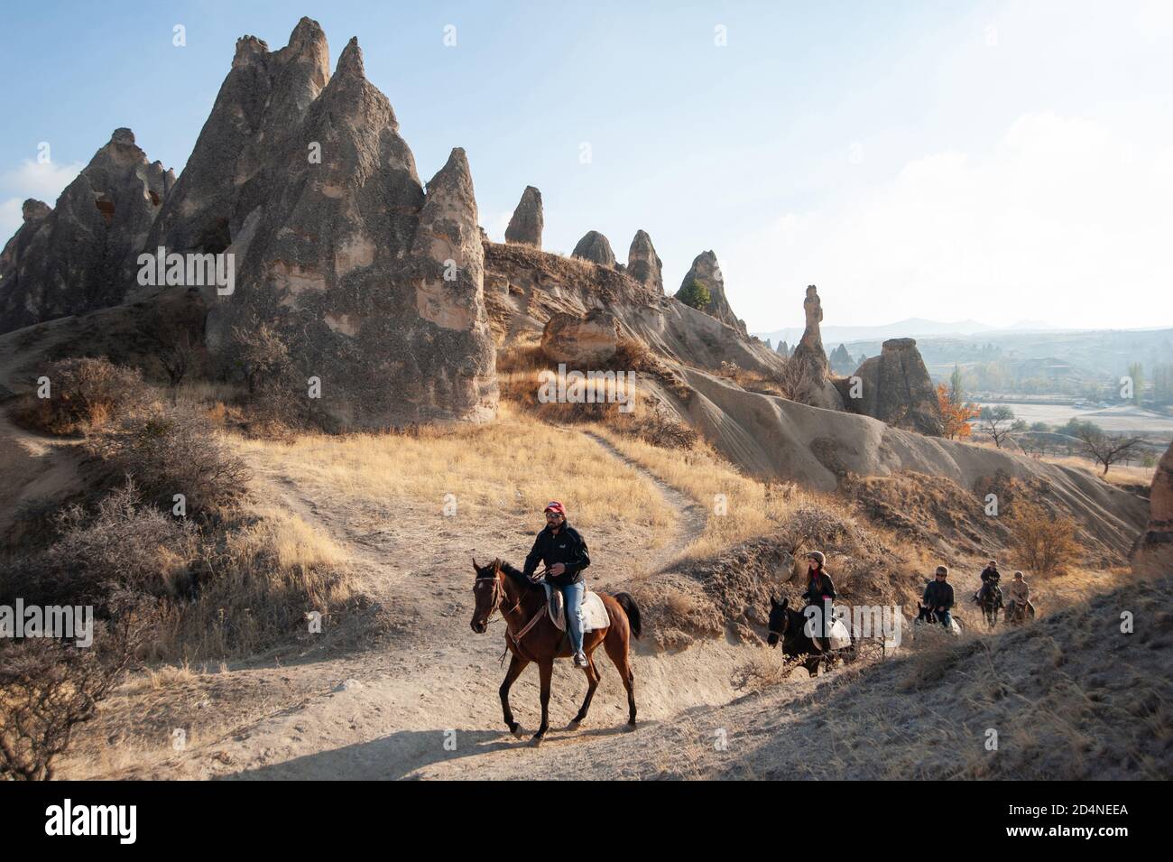 Cappadocia, Turchia. 8 novembre 2017 Canan conduce un gruppo di trekking turistico a cavallo attraverso il paesaggio vulcanico della Cappadocia nel centro di Anatoli Foto Stock