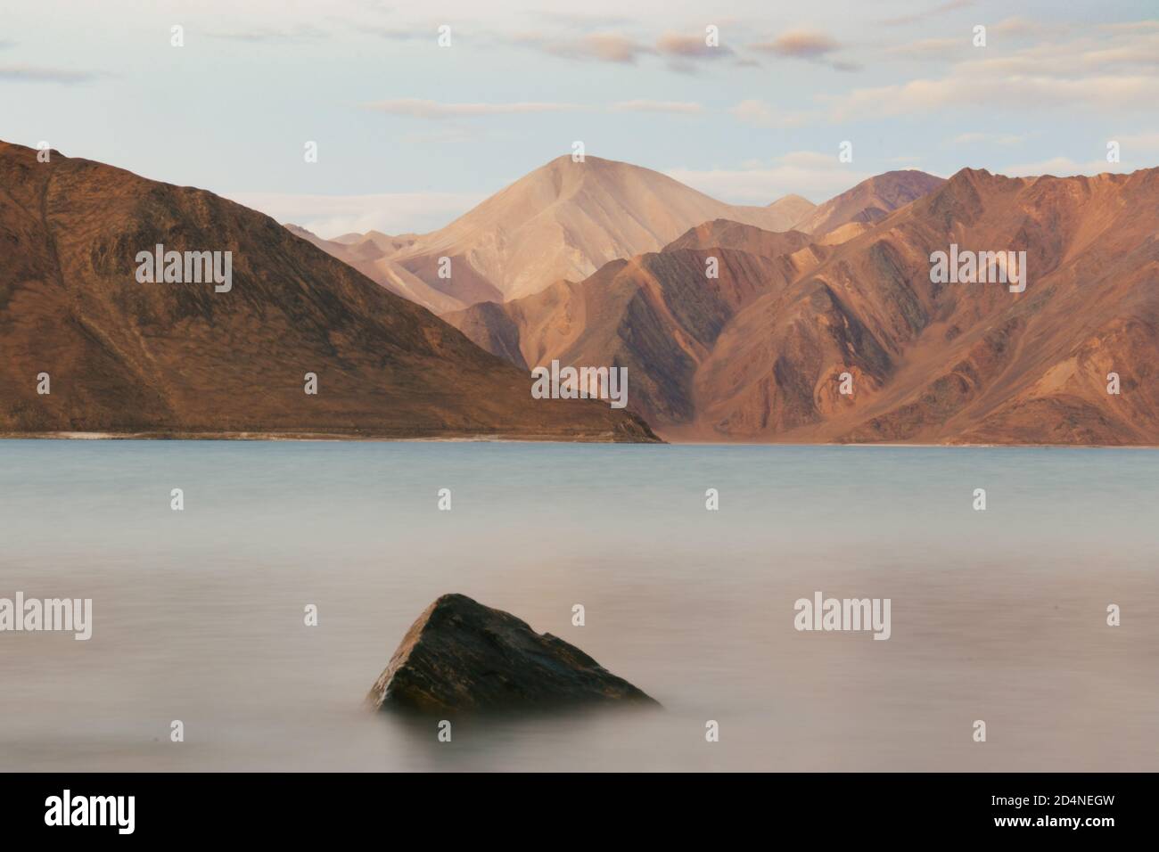 Lunga esposizione Foto di paesaggio del lago Pangong con montagne aride al tramonto in Ladakh, India. Foto Stock