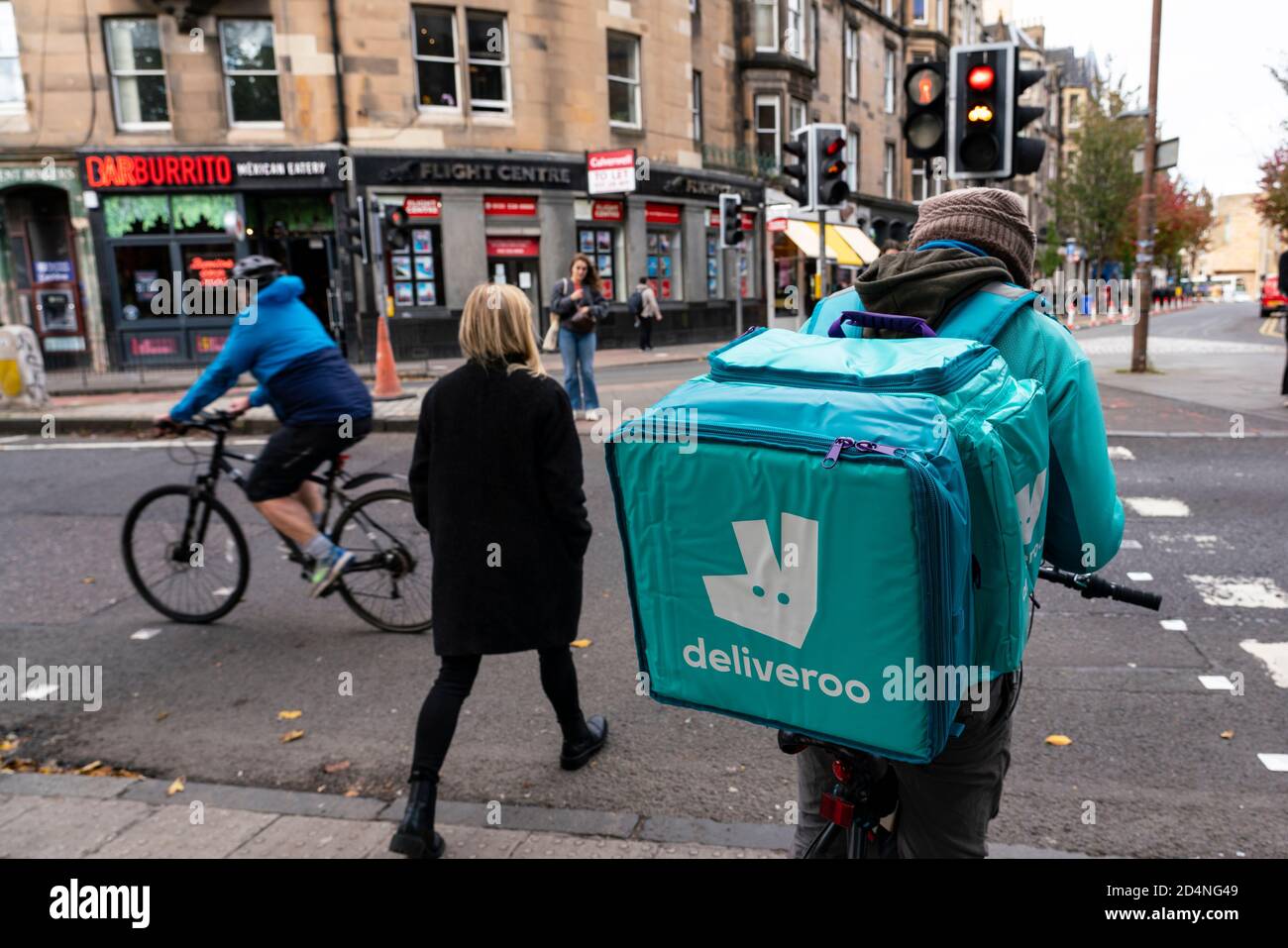 Corriere di consegna del ciclo Deliveroo sulla strada a Edimburgo, Scozia, Regno Unito Foto Stock