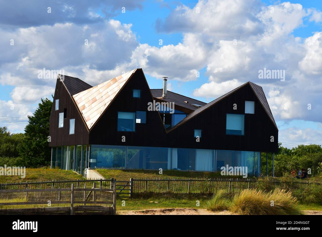 Una casa accanto alla spiaggia a Thorpeness, Suffolk, Regno Unito. Insolita architettura moderna - finestre da parete a parete al piano terra. Foto Stock