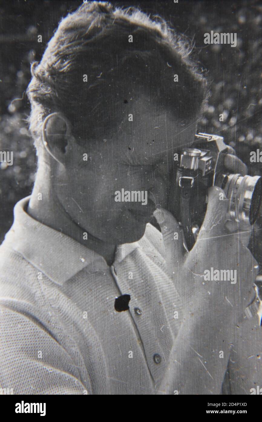 Fine 1970 vintage fotografia in bianco e nero di un hobbista shutterbug che prende la macchina fotografica fuori per una coppia di immagini. Foto Stock