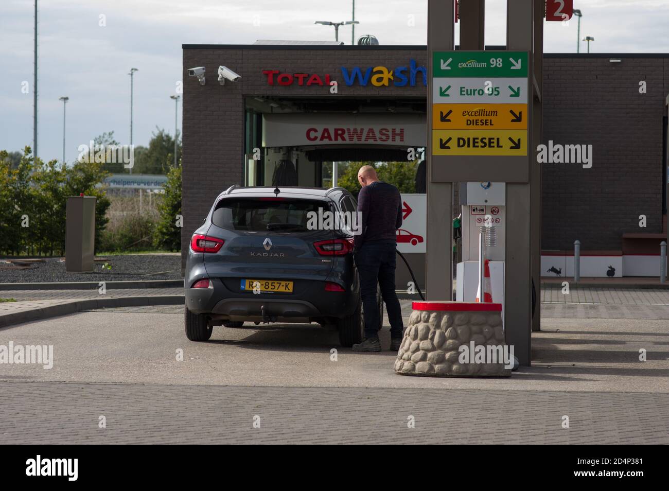 Arnhem, Paesi Bassi - 2 ottobre 2020: L'uomo riempie la sua auto presso la stazione di servizio Total Foto Stock