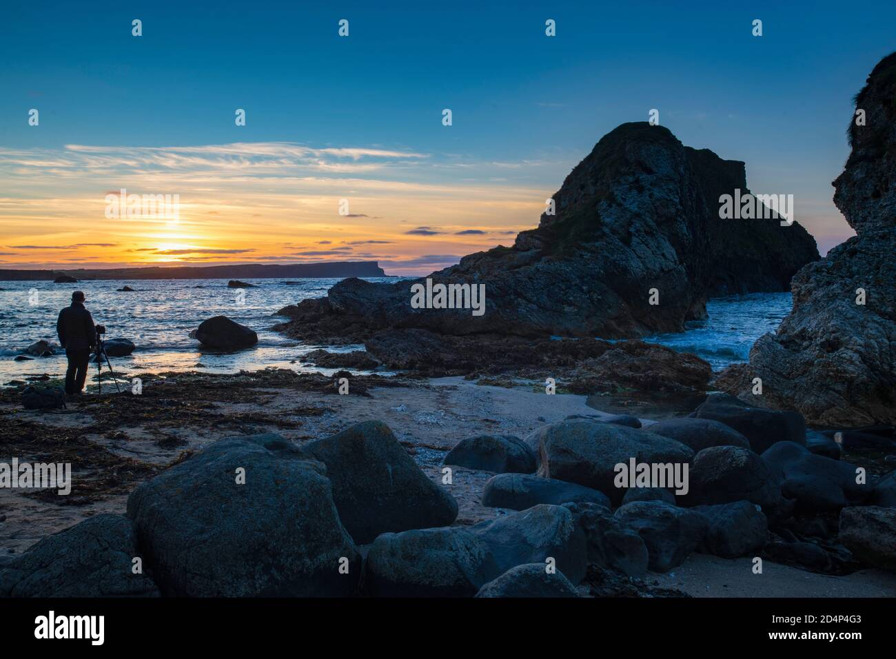 Fotografo che fotografa il tramonto a Ballintoy, White Park Bay, County Antrim, Irlanda del Nord Foto Stock