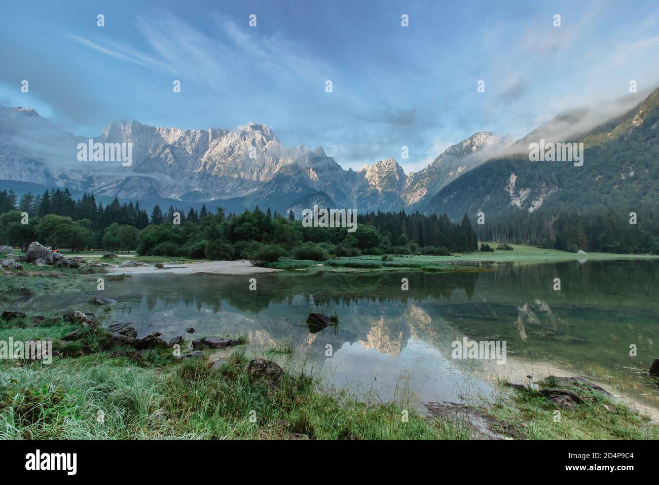 Riflessione specchio in Lago di Fusine, Italia. Estate primavera colori e Mangart montagna sullo sfondo all'alba in Italien Alps.Beautiful tranquillo Foto Stock