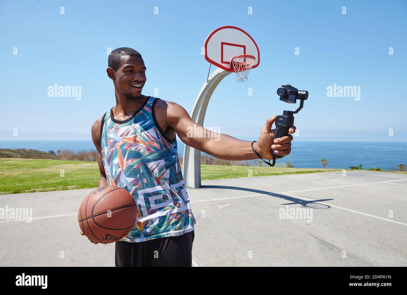 Basketball Player vicino all'oceano con selfie camera Foto Stock