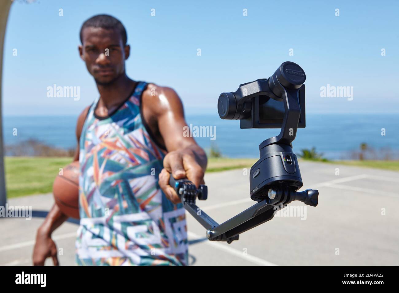 Basketball Player vicino all'oceano con selfie camera Foto Stock