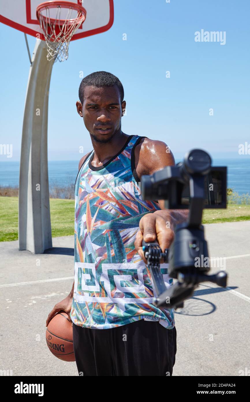 Basketball Player vicino all'oceano con selfie camera Foto Stock
