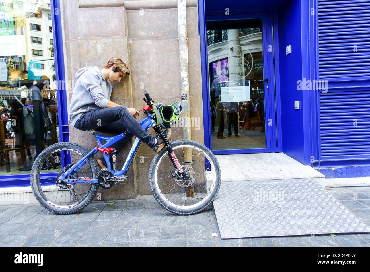 Spagna teenager da solo con un telefono in bicicletta Lifestyle Valencia Spagna lifestyle giovane adolescente adolescente che utilizza la rete di telefonia mobile Foto Stock