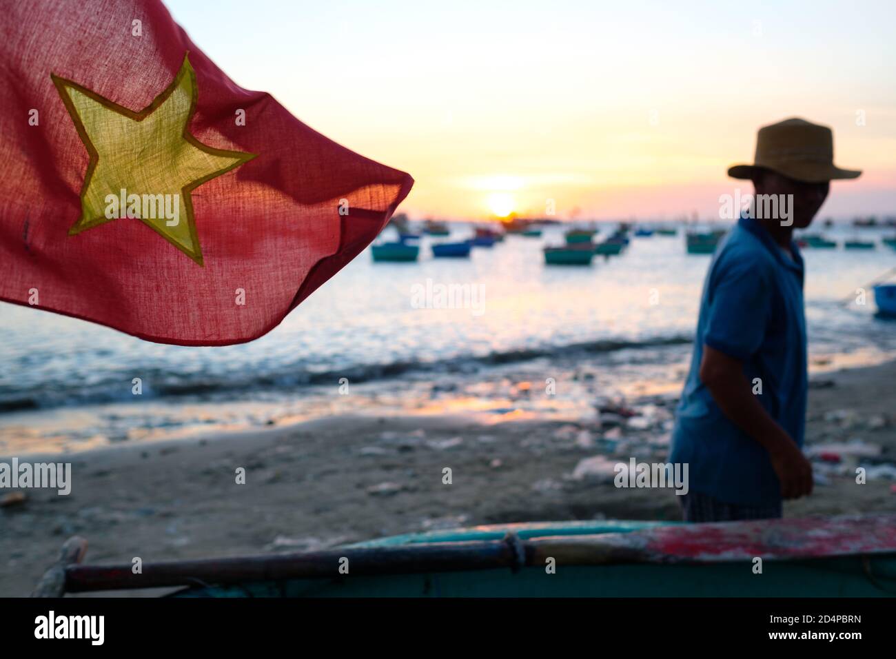 Una bandiera vietnamita con un pescatore sullo sfondo Foto Stock