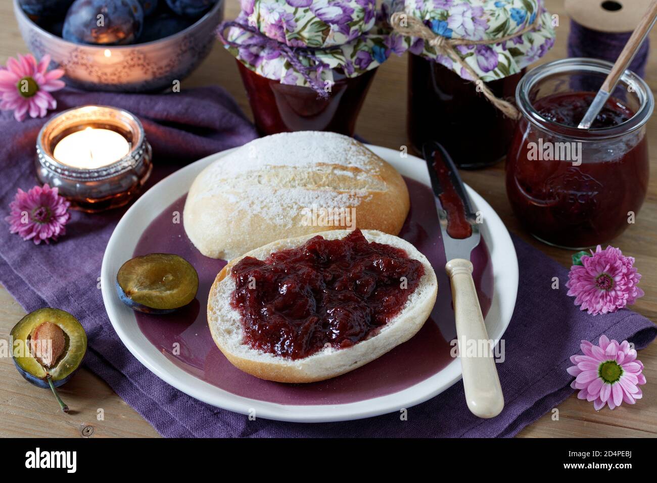 marmellata di prugne sulla decorazione del tavolo del rotolo di pane Foto Stock