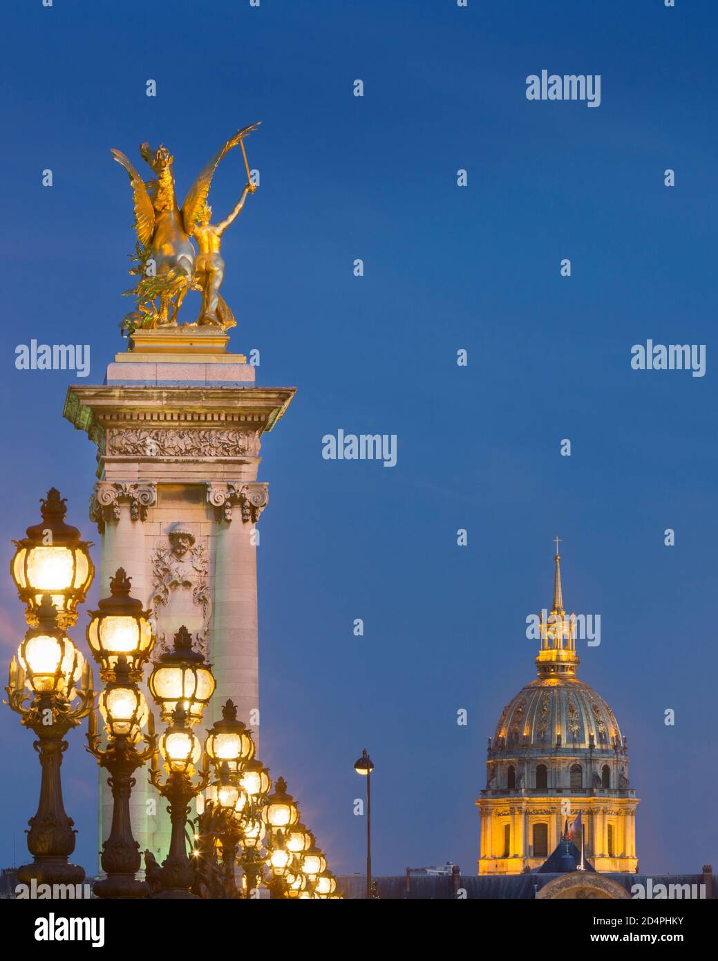 Fila di lampioni lungo Pont Alexandre III con cupola del Hotel des Invalides oltre, Parigi, Francia Foto Stock