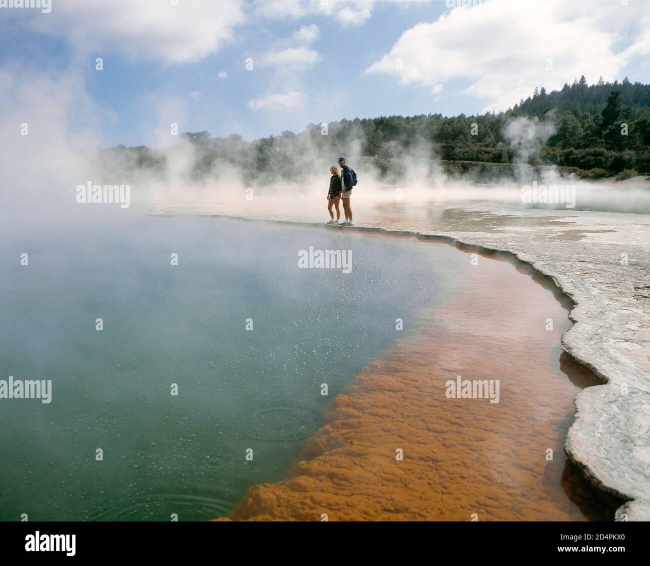 Nuova Zelanda. Isola del Nord. Rotorua. Sorgenti termali di Waiotapu. Giovane coppia in piedi al bordo della piscina. Foto Stock