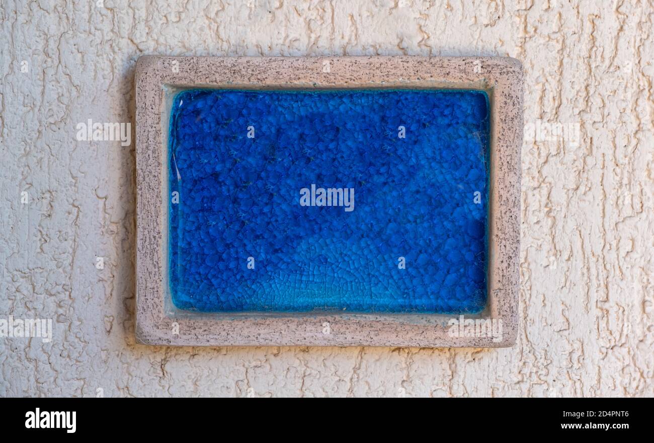 Cartoncino vuoto, vuoto, segno di colore blu brillante, cornice in pietra su sfondo beige intonacato ruvido, vista ravvicinata. Modello di firma, spazio di copia, Foto Stock