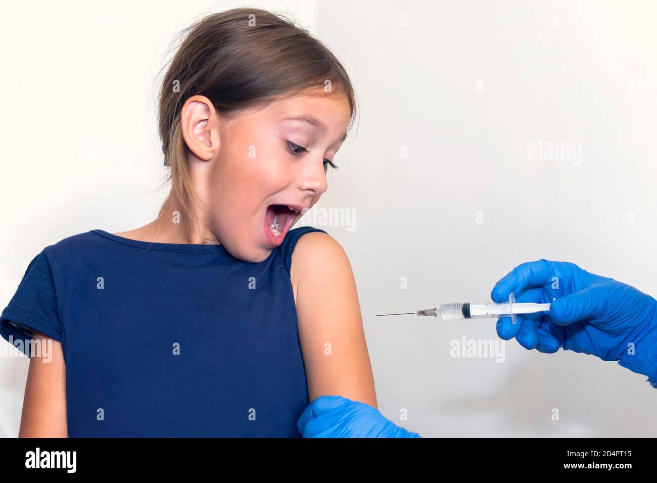 la ragazza urla nel timore di essere sparata nella spalla. Vaccinazione contro malattie virali pericolose. Prevenzione e protezione dai virus. Iniezione di Foto Stock