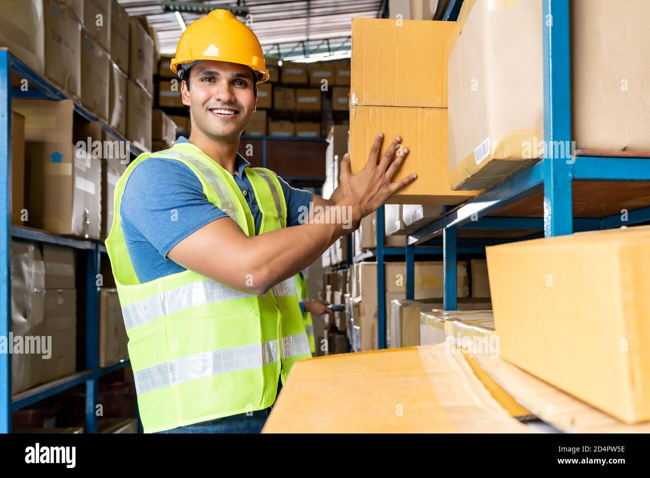 Il lavoratore indiano di magazzino ha messo scatola di cartone in scaffale con islam musulmano asiatico lavoratore fare l'inventario in magazzino ambiente centro di distribuzione. Uso di Foto Stock