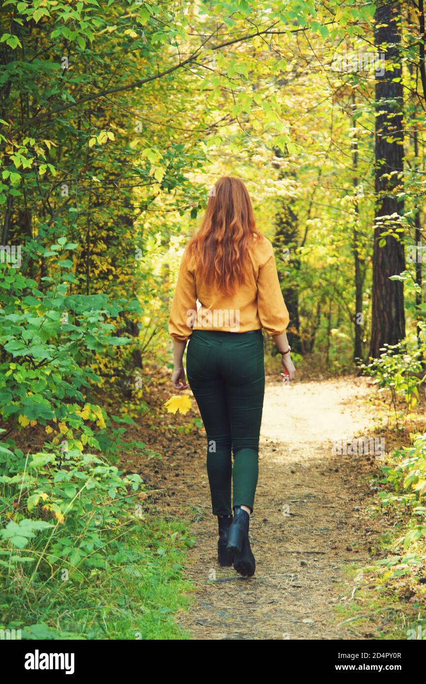 bella donna rossa per una passeggiata nella foresta d'autunno. Foto Stock