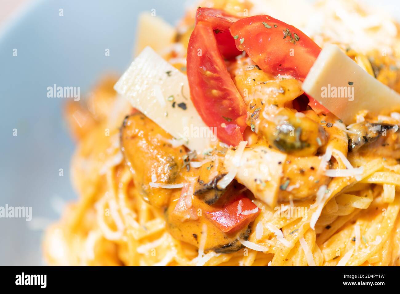 Gustosa e appetitosa pasta italiana di spaghetti con salsa, parmigiano e basilico sul piatto. Foto Stock