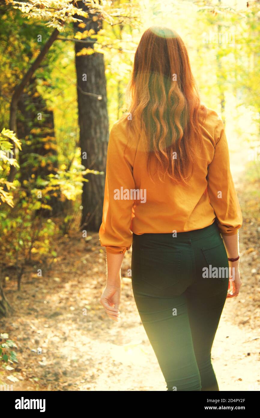 bella donna rossa per una passeggiata nella foresta d'autunno. Foto Stock
