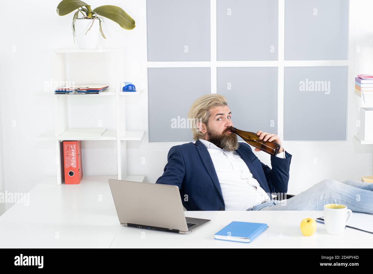 Un uomo d'affari ubriaco annoiato in ufficio alla fine della giornata lavorativa. Uomo d'affari ubriaco. Foto Stock