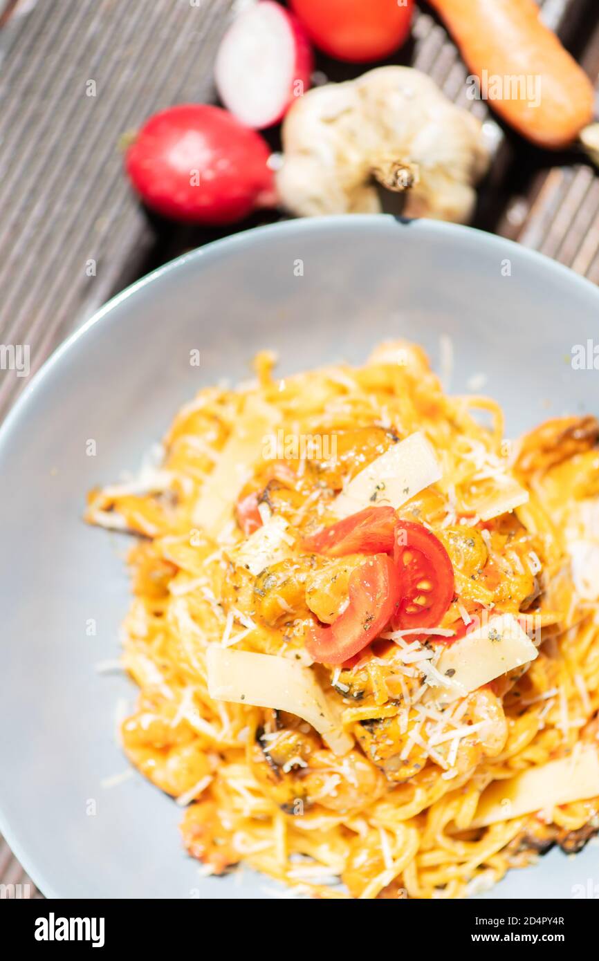 Gustosa e appetitosa pasta italiana di spaghetti con salsa, parmigiano e basilico sul piatto. Foto Stock