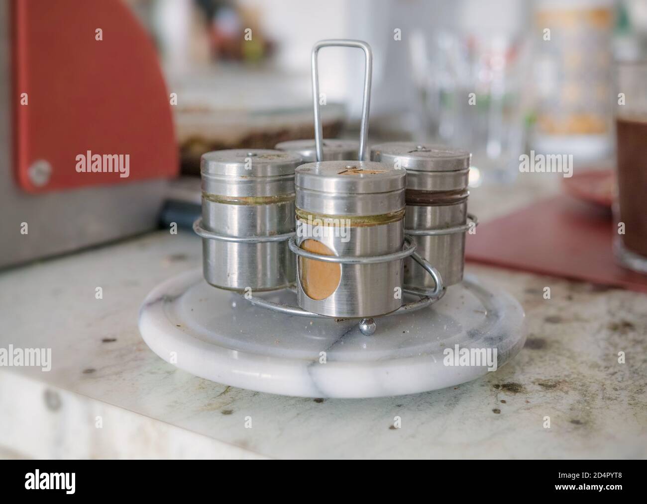 Sul banco della cucina è presente un set di contenitori per spezie. Uno di questi è curcuma. Foto Stock