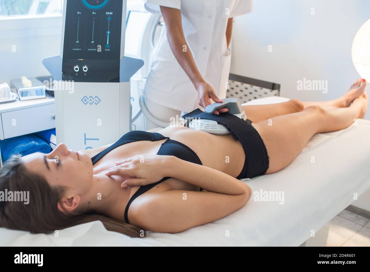 Emsculpt® Session per un rimodellamento non invasivo della silhouette, Emsculpt® permette di guadagnare massa muscolare e ridurre il grasso inviando un segnale elettromagnetico Foto Stock