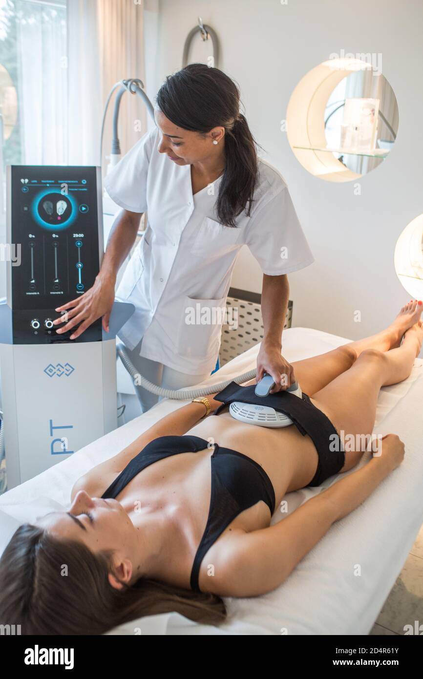 Emsculpt® Session per un rimodellamento non invasivo della silhouette, Emsculpt® permette di guadagnare massa muscolare e ridurre il grasso inviando un segnale elettromagnetico Foto Stock