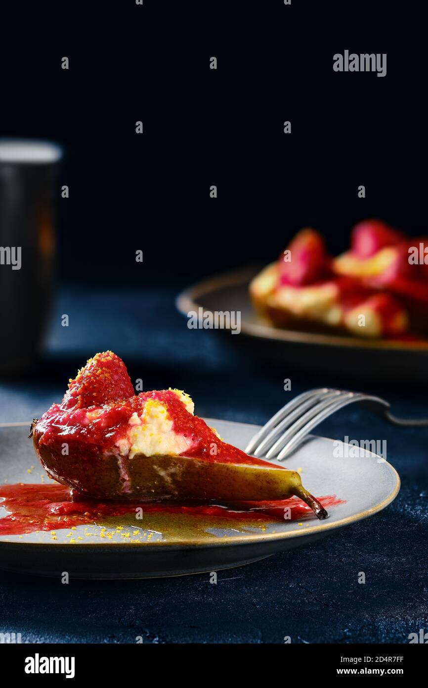 Pere dolci al forno con mascarpone, sciroppo di caramello e confettura di fragole Foto Stock