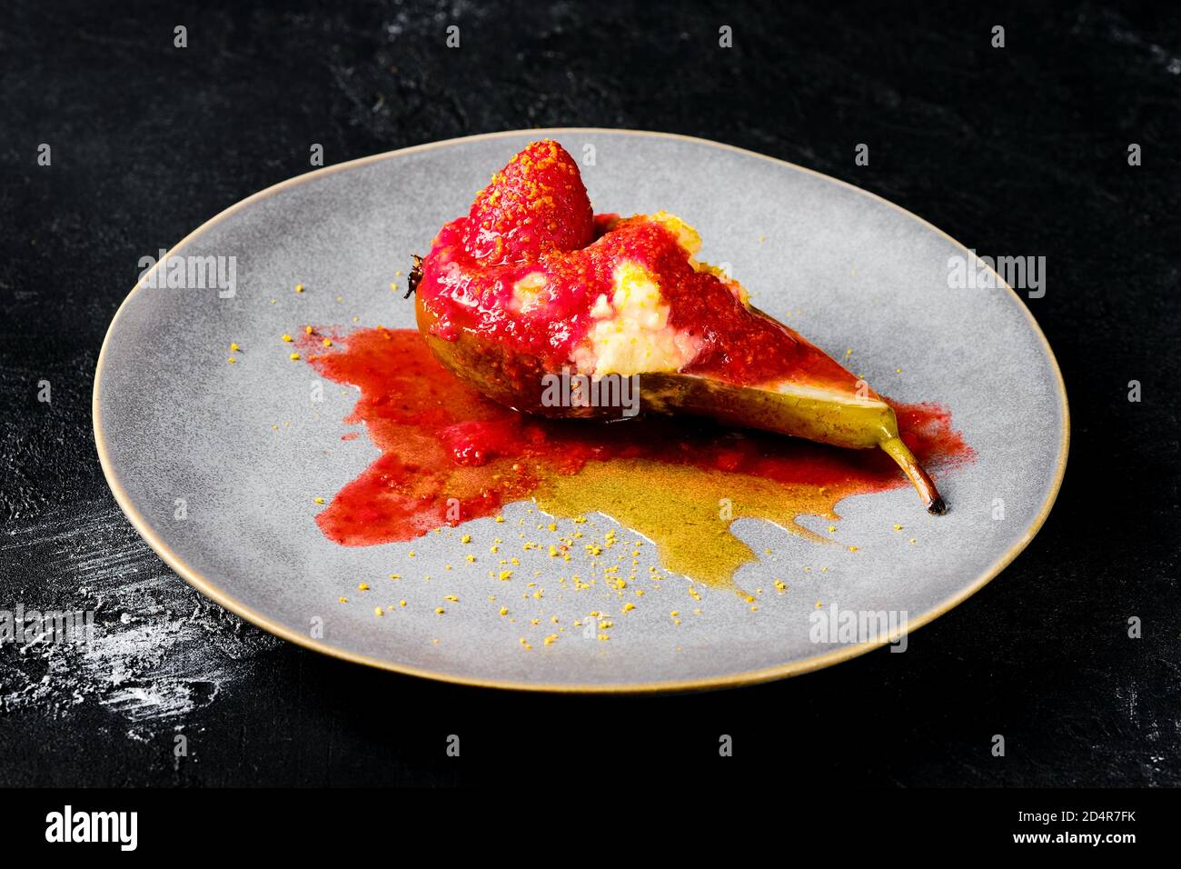 Piatto con pere dolci al forno con mascarpone, sciroppo di caramello e marmellata di fragole Foto Stock