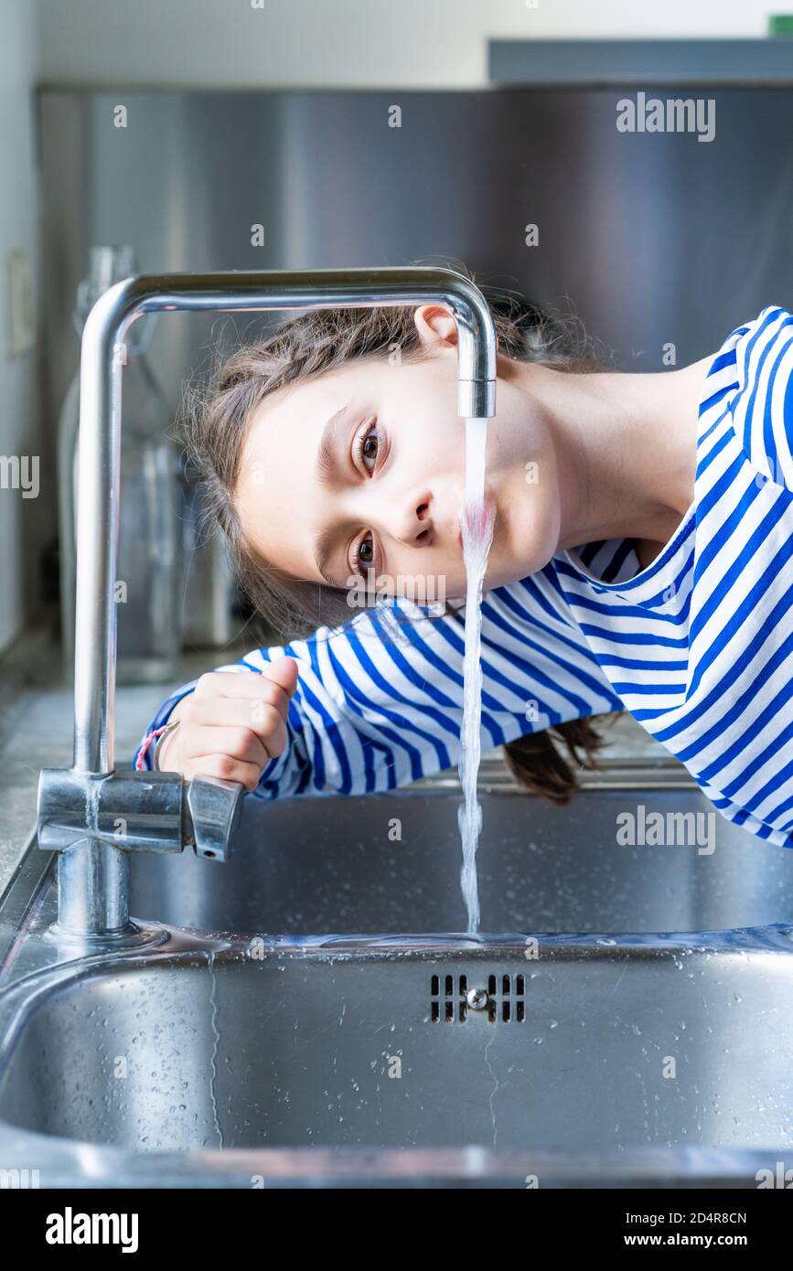 ragazza di 12 anni che beve acqua di rubinetto. Foto Stock