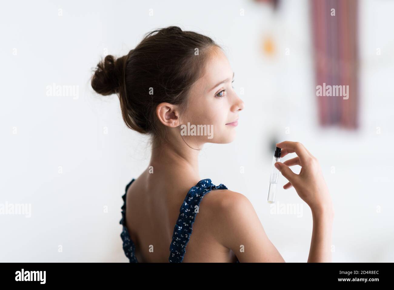 ragazza di 12 anni che applica il perfum. Foto Stock