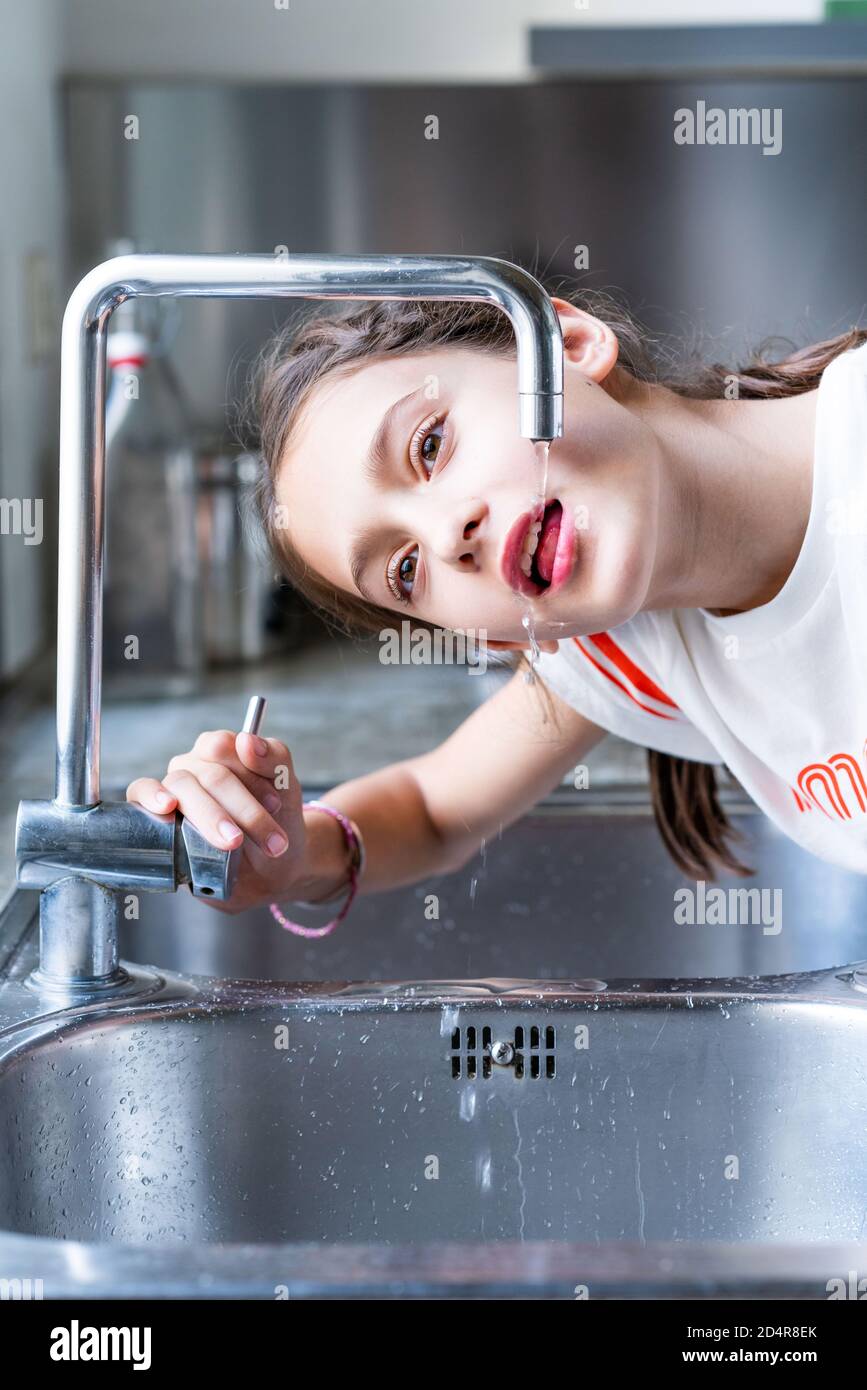 ragazza di 12 anni che beve acqua di rubinetto. Foto Stock