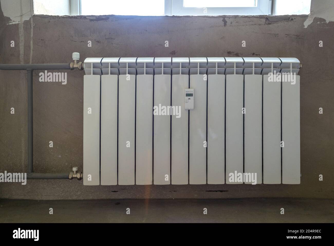 Radiatore di riscaldamento in metallo bianco su parete in cemento Foto Stock