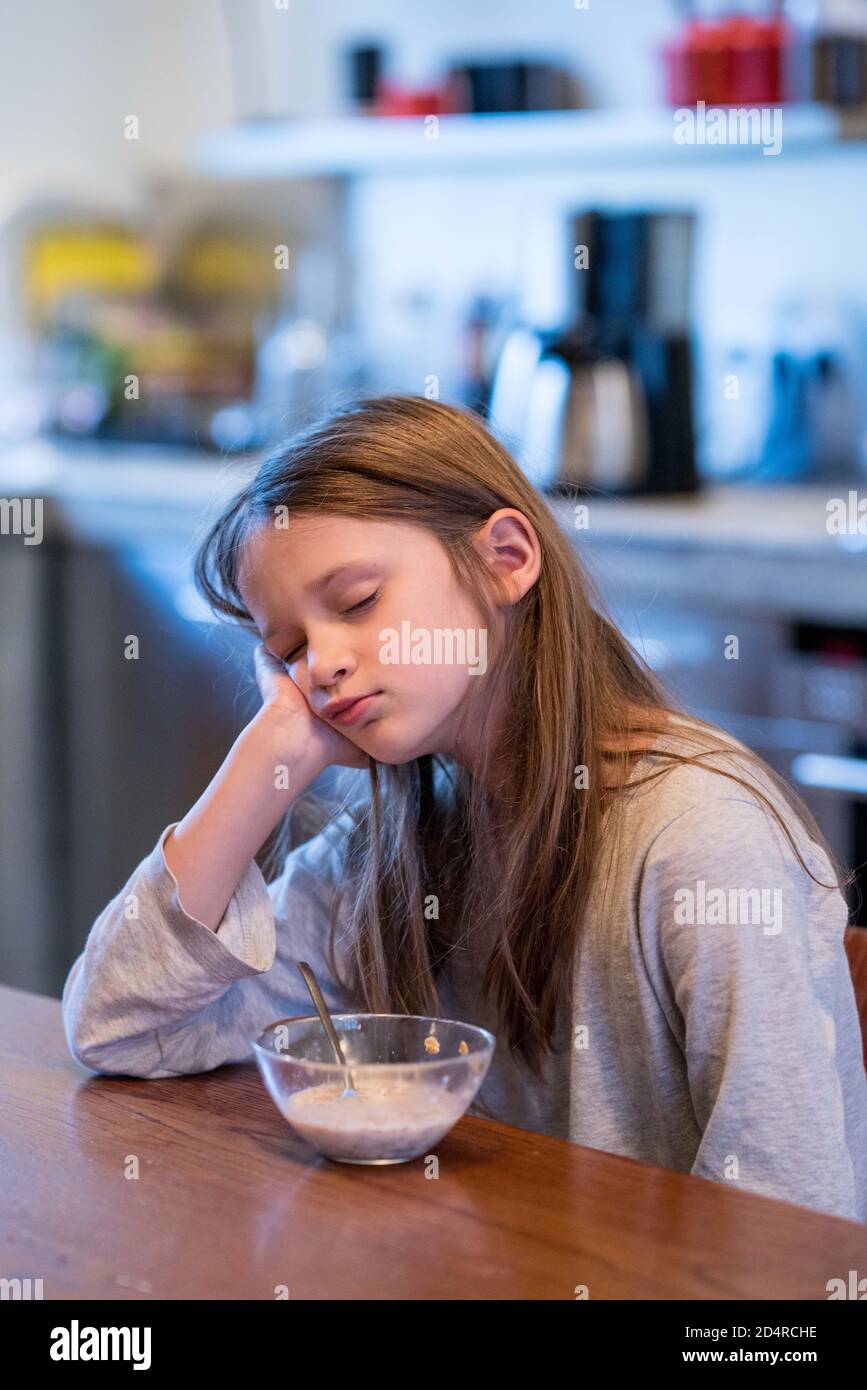 8 anni ragazza che ha la sua colazione. Foto Stock
