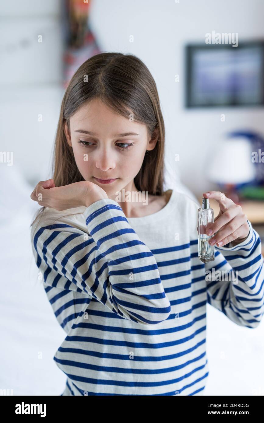 ragazza di 10 anni che applica il perfum. Foto Stock
