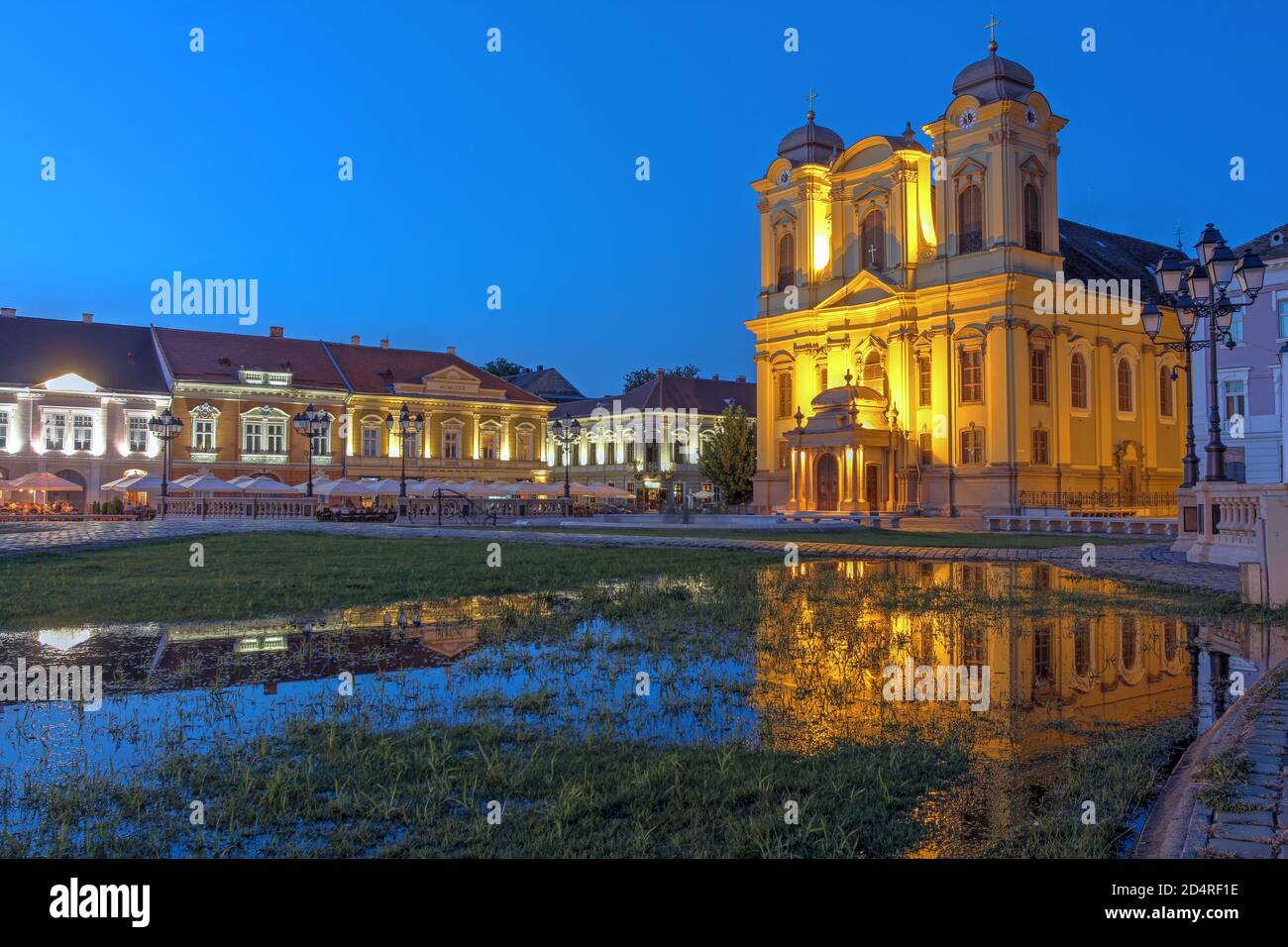 Scena notturna in Piazza Unirii (Union Square), Timisoara, Romania con la chiesa di San Giorgio (cupola), che si riflette in una piscina a seguito di una pioggia estiva. Foto Stock