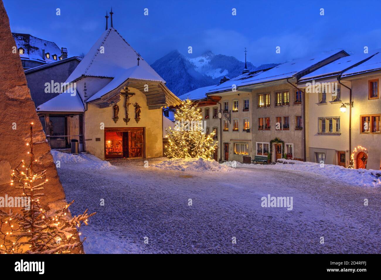 Scena notturna invernale (Natale) nella città medievale di Gruyeres, quartiere di Gruyere, Cantone di Friburgo, Svizzera. La città diede il nome al famo Foto Stock