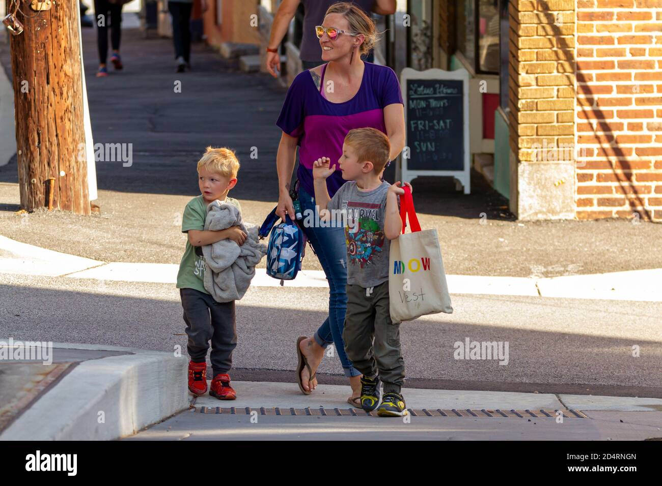 Ellicott City, MD USA 10/07/2020: Una sola madre caucasica con due ragazzini camminano per strada insieme. Nonostante i ragazzi attivi, giovane madre Foto Stock
