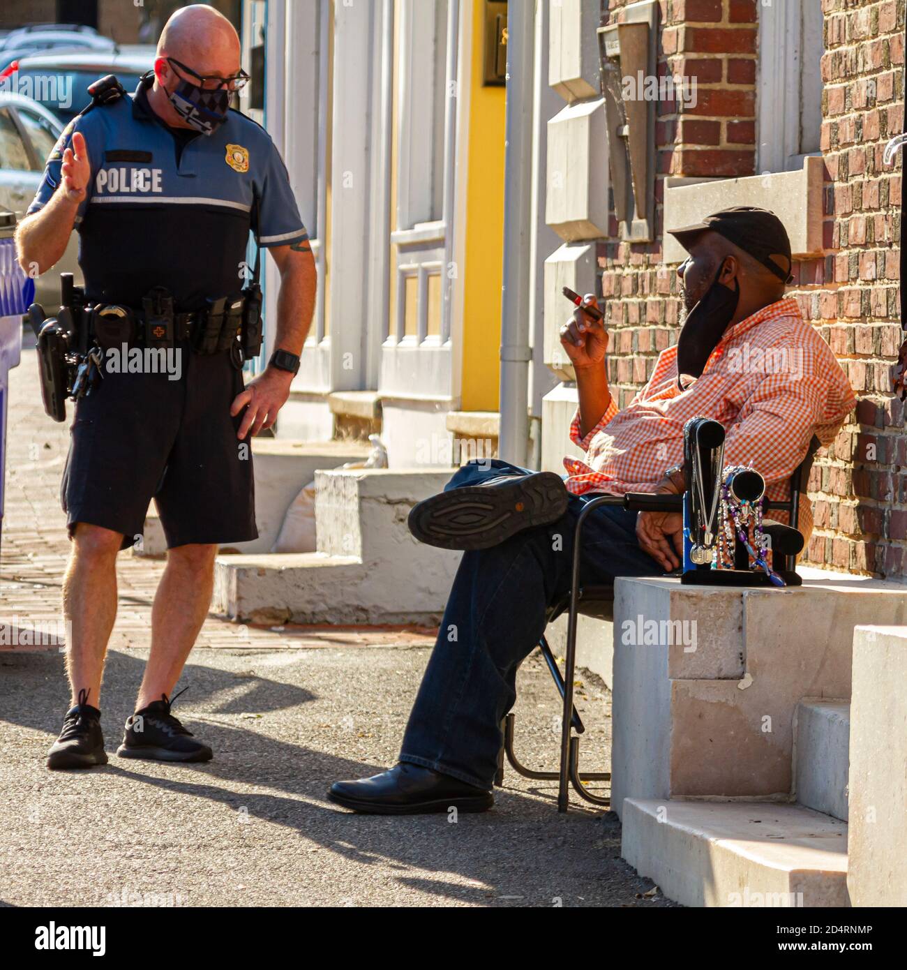 Ellicott City, MD, USA 10/07/2020: Un poliziotto bianco con testa rasata che indossa una divisa di tipo maglia corta e t e una maschera facciale sta parlando con Foto Stock